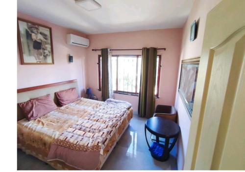 a bedroom with a bed and a window at Georgios Villa in Grand-Baie