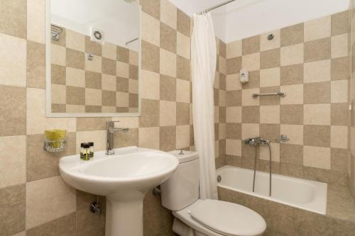 ein Badezimmer mit Waschbecken, Toilette und Badewanne in der Unterkunft Galaxy New Hotel in Pylos
