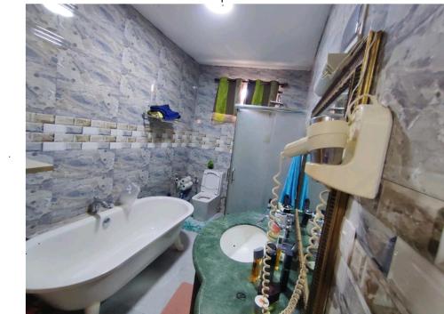 a bathroom with a tub and a sink and a guitar at Georgios Villa in Grand-Baie