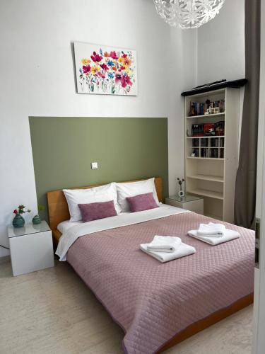 a bedroom with a large bed with two towels on it at Villeni Panorama Apartment Oktonia in Okhthonía