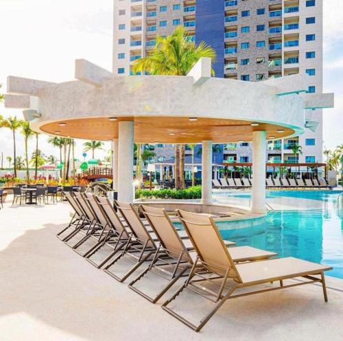 a group of chairs sitting next to a swimming pool at Salinas Exclusive Resort in Salinópolis