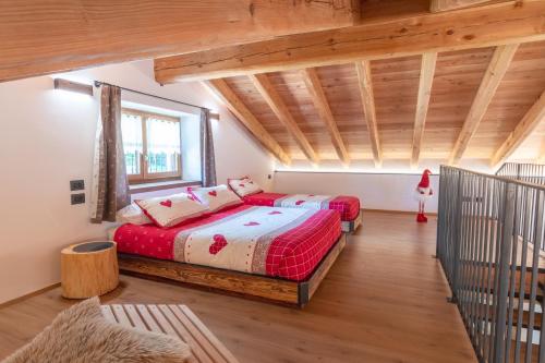 a bedroom with two beds in a room with wooden ceilings at Chalet Grifone - Chalet Maso Vecchio nel cuore del Lagorai Trentino in Castello Tesino