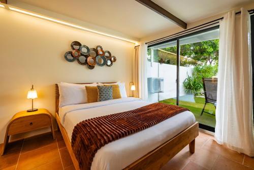 a bedroom with a bed and a large window at Esensia Boutique Studio in Oranjestad