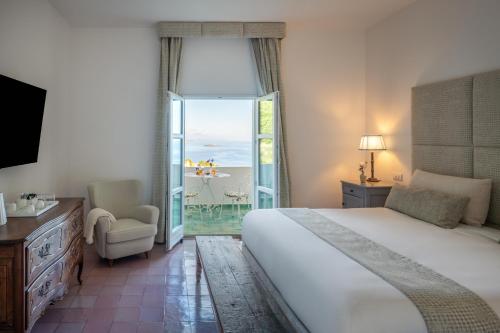 a bedroom with a bed and a view of the ocean at Santavenere Hotel - The Leading Hotels of the World in Maratea