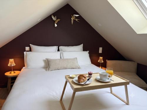 a bedroom with a bed with a tray of food on it at Bulles et cocon in La Roche-Bernard