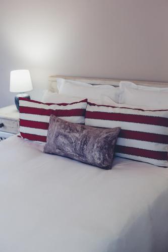 a white bed with several pillows on top of it at Station House Simondium in Simondium
