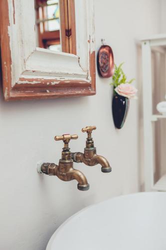 a bathroom sink with a mirror and a faucet at Station House Simondium in Simondium