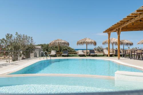 a large swimming pool with chairs and umbrellas at Golden Sand in Plaka