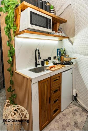 a small kitchen with a microwave and a sink at Eco Glamping Manglaralto in Santa Elena