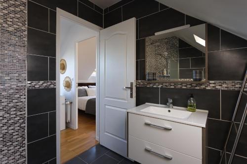 a bathroom with a sink and a mirror at Chambre d'hôtes près du Château in Sully-sur-Loire
