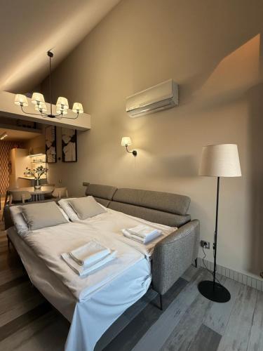 a bedroom with a large bed and a couch at OrkanaApart in Nowy Targ