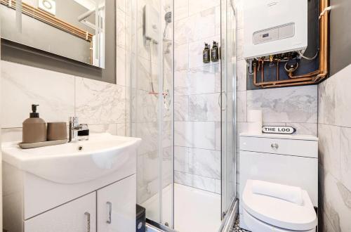 a bathroom with a toilet and a sink and a shower at Chic Flat Hideaway with Private Courtyard - Pass the Keys in Guildford