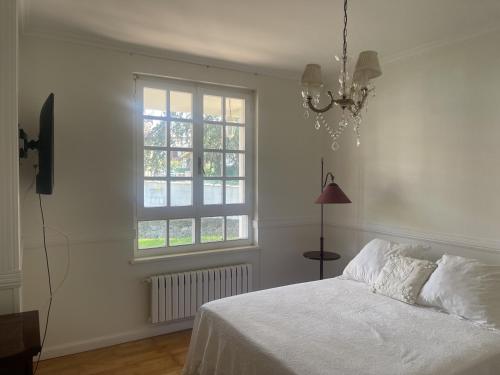 a bedroom with a white bed and a window at Casa Sierrapando - by Wehomes in Torrelavega