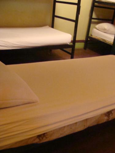 two beds in a room with white sheets at Intiaconcagua Habitacion familiar con baño privado in Ciudad Lujan de Cuyo