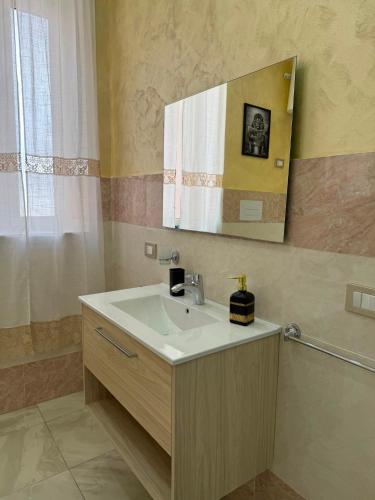 a bathroom with a sink and a mirror at Maison D'orleans By Catalano in Palermo