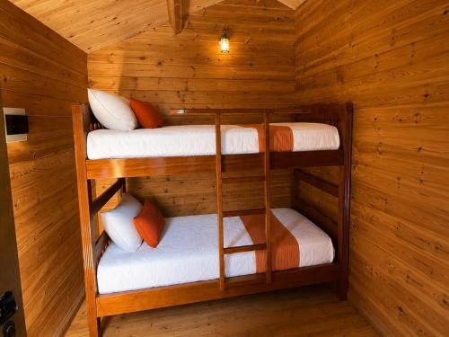 a room with three bunk beds in a cabin at Llogara Wood Lodge in Vlorë