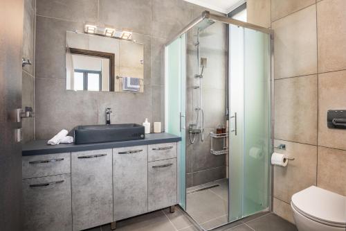 a bathroom with a sink and a glass shower at Summer & Sun in Vathí