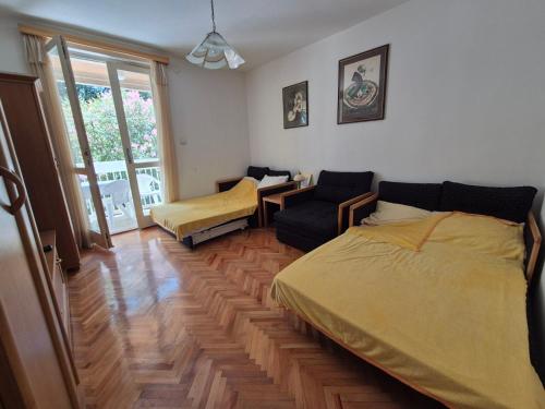 a bedroom with a bed and a chair and a window at Drača in Savina