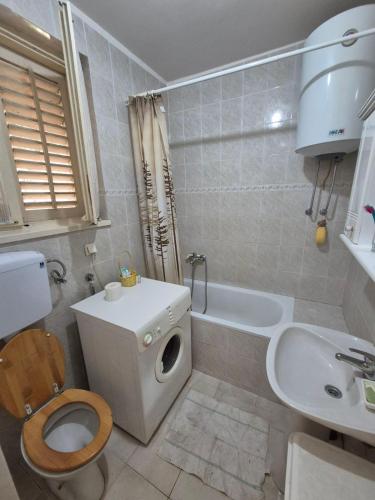 a white bathroom with a toilet and a sink at Drača in Savina