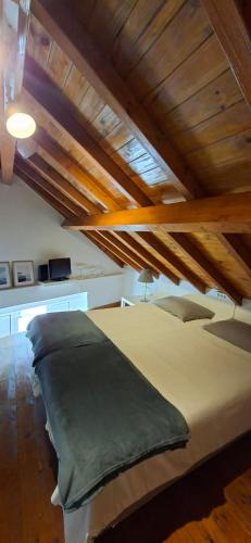a large bed in a room with wooden ceilings at Casa do Tejo de Alcochete in Alcochete