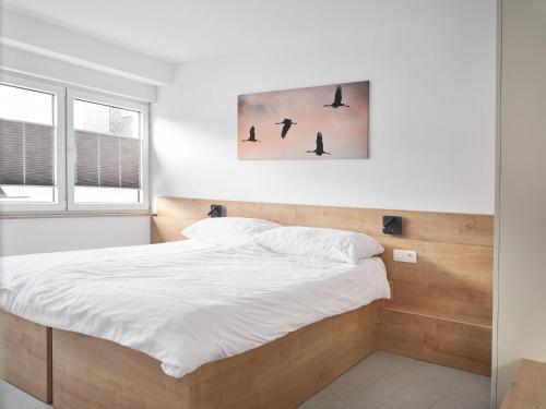 a bedroom with a bed with white sheets at Aparthouse HAAS41 - Eupen in Eupen