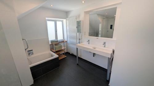 a bathroom with two sinks and a bath tub and a tubermott at Ferienwohnung Malbrich in Gräfenberg