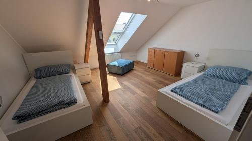 a attic bedroom with two beds and a window at Ferienwohnung Malbrich in Gräfenberg