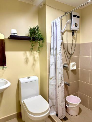 a bathroom with a toilet and a shower at Avida Aspira Studio, 27th Floor, Pool & Gym in Cagayan de Oro