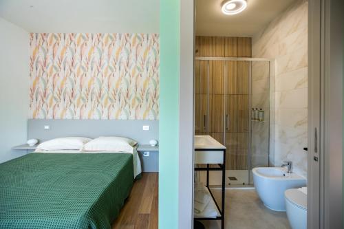 a bedroom with a bed and a bathroom with a sink at Salvia Hotel in Poggio Moiano