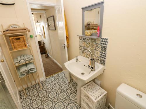 a small bathroom with a sink and a toilet at Arch Mews Cottage in Barnard Castle