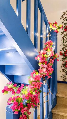 a bunch of flowers in a blue stair case at Casa Mykonos Rio in Rio de Janeiro