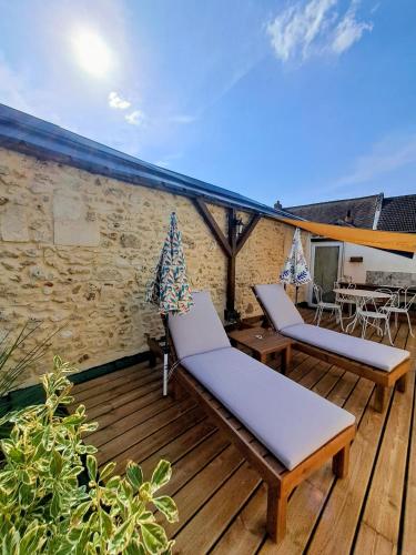 a wooden deck with two chairs and a table at le patio de la Cavée " havre de paix" in Verderonne