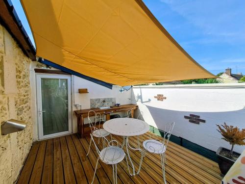 a patio with a table and chairs on a deck at le patio de la Cavée " havre de paix" in Verderonne