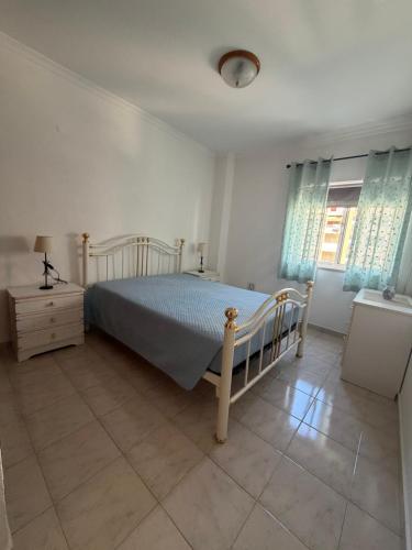 a bedroom with a bed and a dresser and windows at Rabelo C in Armação de Pêra
