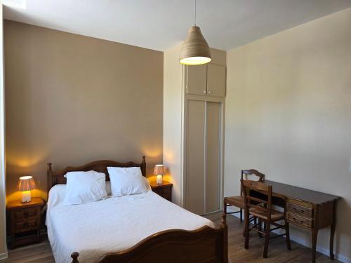 a bedroom with a bed and a desk and a lamp at Maison Lanty in Lanty