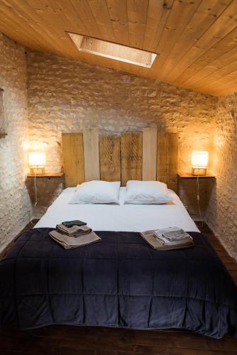 a bedroom with a large bed with two towels on it at Têtes à l'air in Montils