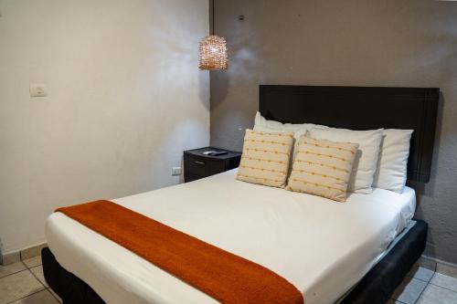 ein Schlafzimmer mit einem großen weißen Bett und zwei Kissen in der Unterkunft Coco Suites by Andiani Travel in Cancún