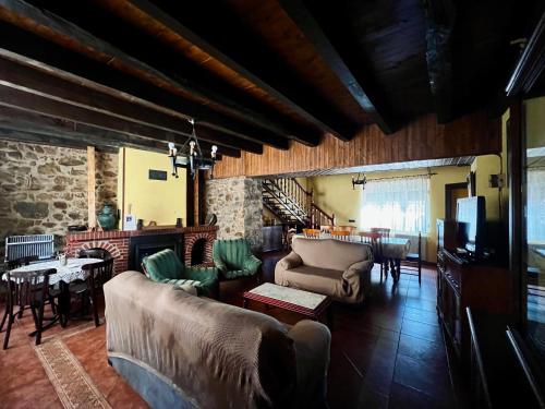 a living room with a couch and chairs and a table at El Rincón de la Rosa in Brugos de Fenar