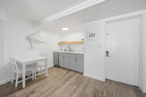 a white kitchen with a table and a white door at Inn on the Beach in St. Pete Beach
