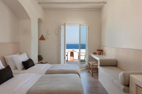 a hotel room with two beds and a view of the ocean at Porto Mykonos in Mikonos