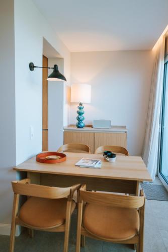 a dining room table with chairs and a lamp at Sünn un See - Weststrand-Blick mit Sauna in Ahrenshoop