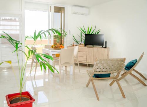 a living room with a tv and a table and chairs at Charmant T1 - Vue Mer in Pointe-à-Pitre