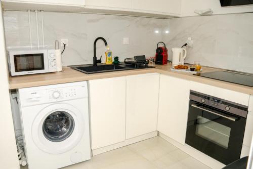 a kitchen with a washing machine and a microwave at Charmant T1 - Vue Mer in Pointe-à-Pitre