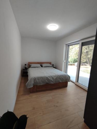 a bedroom with a bed and a large window at Apartma Pod Hrastom in Koper
