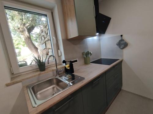 a kitchen with a sink and a window at Apartma Pod Hrastom in Koper
