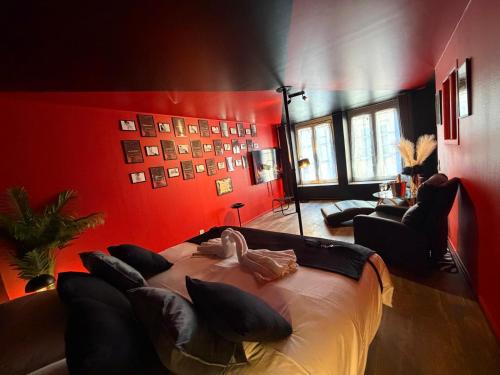 a bedroom with a large bed and red walls at L'Atelier des Amoureux studio à 2 pas du château in Sedan