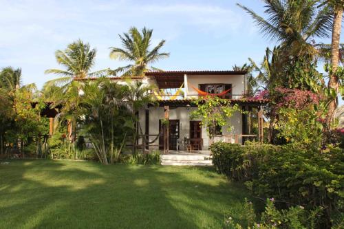 a house with a lawn in front of it at Pousada Barra do Mundaú in Lavagem