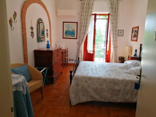 a bedroom with a bed and a chair and a window at Villa Remignoli in San Gimignano