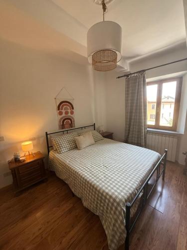 a bedroom with a bed with a checkered blanket and a window at La curva del Serpente in Abbadia San Salvatore