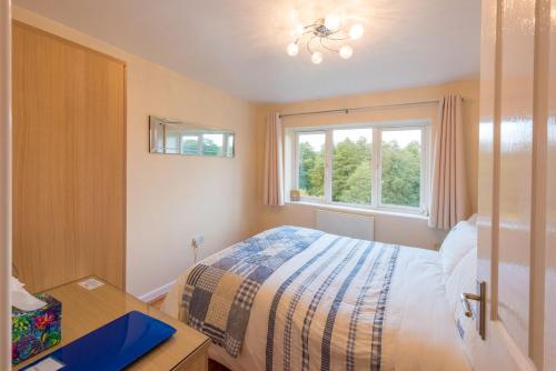 a bedroom with a bed and a desk and a window at Cul Mor B&B in Eccleshall